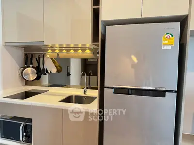 Modern kitchen with sleek cabinetry and stainless steel appliances in a stylish apartment.