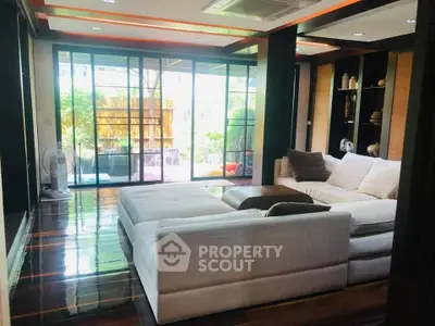 Luxurious living room with large windows and modern decor, perfect for relaxation and entertaining.