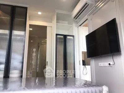 Modern bedroom with sleek design, featuring a wall-mounted TV and air conditioning for ultimate comfort.