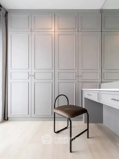 Elegant bedroom with built-in wardrobe and stylish chair