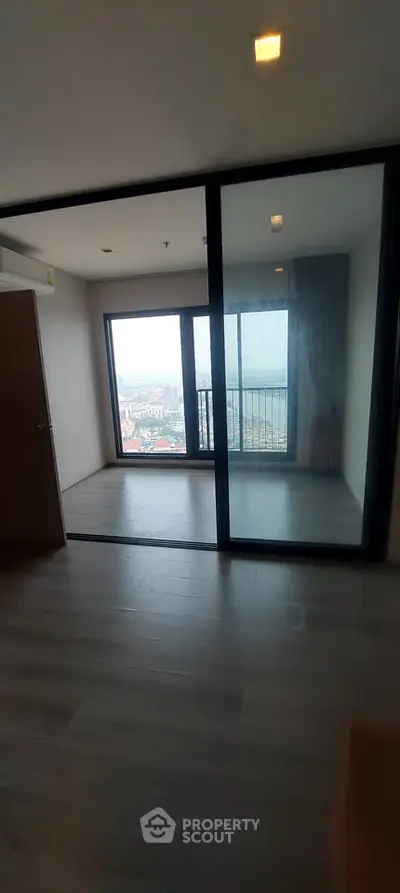 Spacious room with large windows offering stunning city views, perfect for modern living.