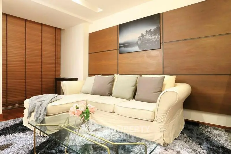 Elegant living room with cozy sofa, modern decor, and stylish glass coffee table in a chic apartment.