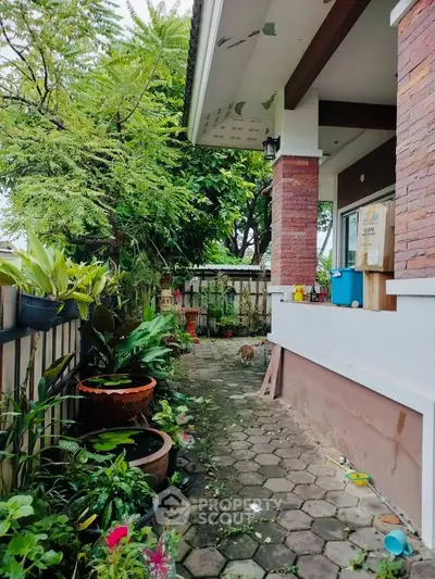 Charming garden pathway leading to a cozy home entrance with lush greenery and brick accents.