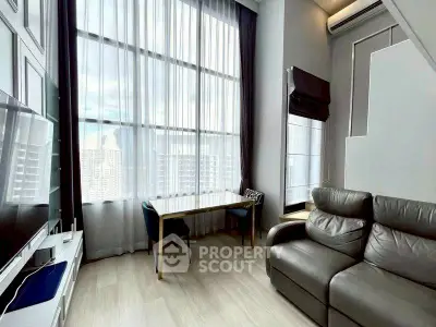 Modern living room with high ceilings and large windows offering city views.