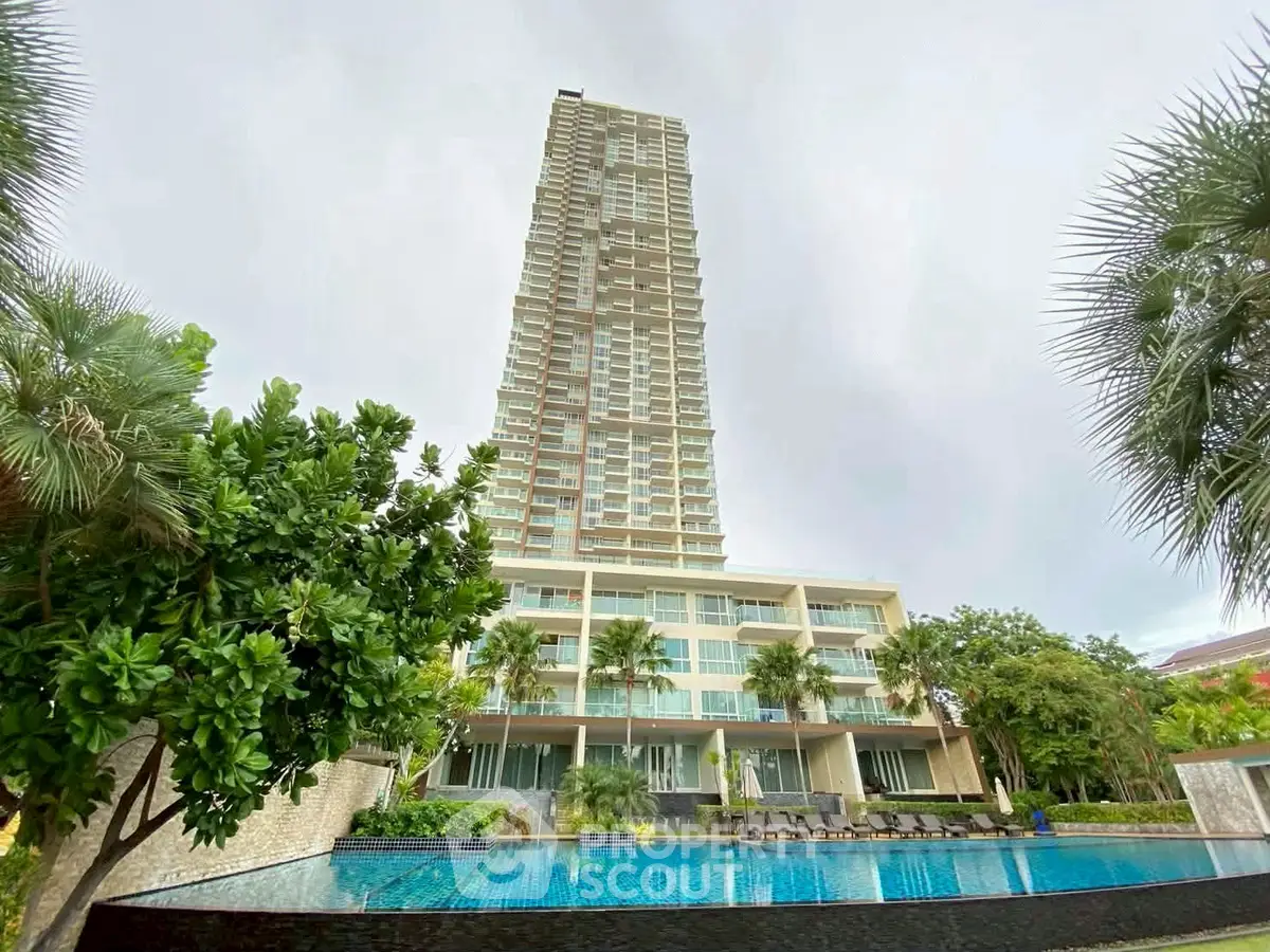 Luxurious high-rise building with stunning pool and lush greenery, perfect for modern living.