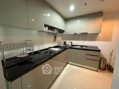 Modern kitchen with sleek cabinetry and black countertops in a stylish apartment.