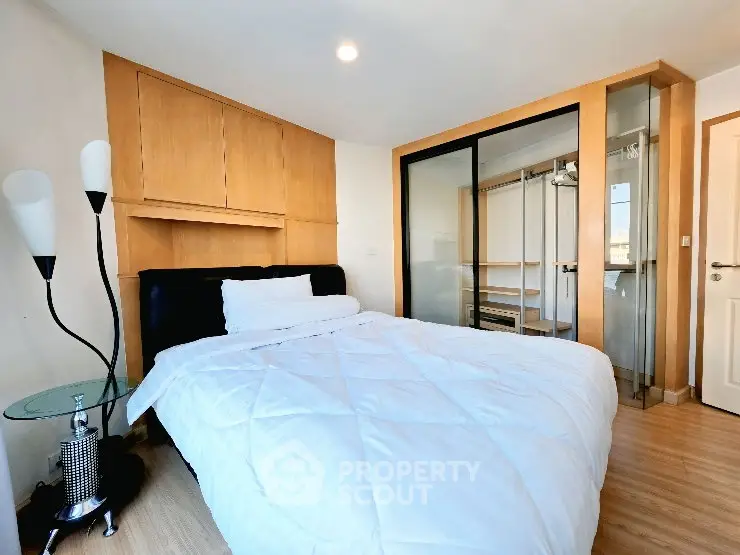 Modern bedroom with stylish wooden accents and glass wardrobe doors