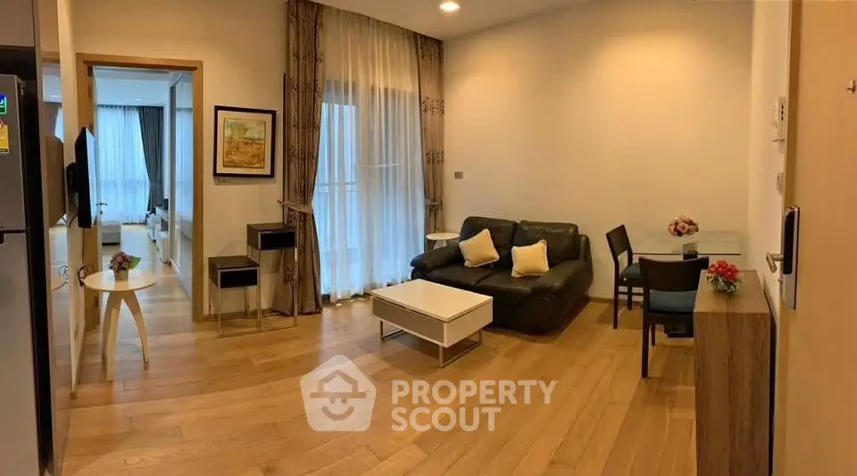Spacious living room with modern decor and wooden flooring, perfect for relaxation and entertaining.