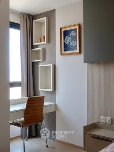 Modern study nook with stylish chair and wall shelves in a bright apartment corner.