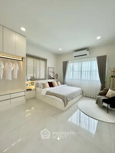 Spacious modern bedroom with elegant decor and ample natural light