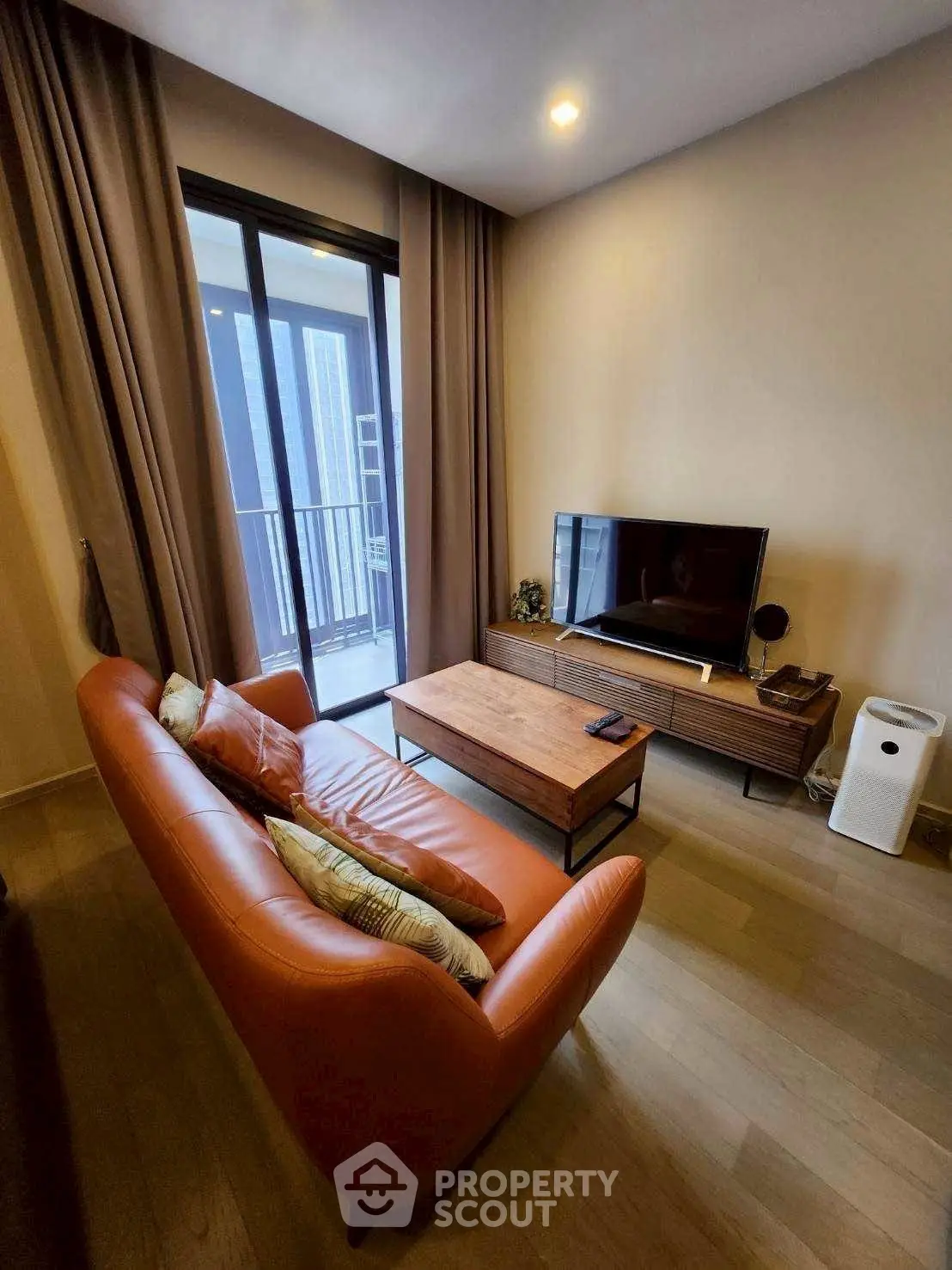 Modern living room with leather sofa and balcony view in a stylish apartment.