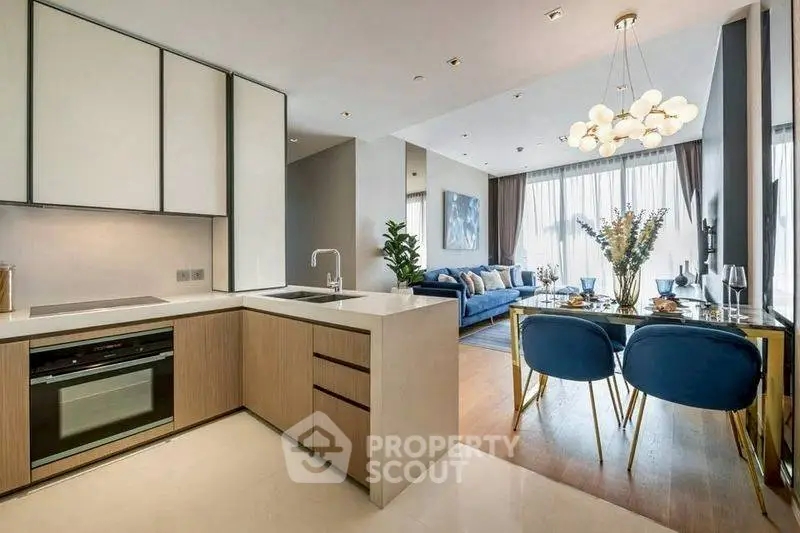 Modern open-plan kitchen and living room with elegant decor and natural light