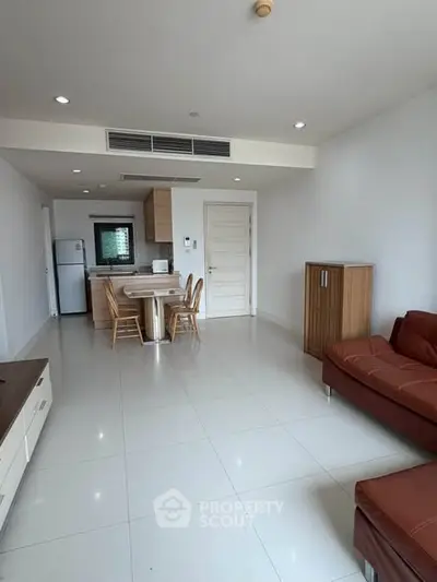 Spacious modern living room with sleek furniture and open kitchen layout in a contemporary apartment.