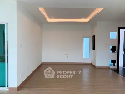 Spacious modern living room with recessed lighting and wooden flooring