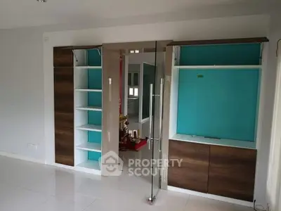Modern interior with built-in wooden cabinets and glass door in a sleek living space.