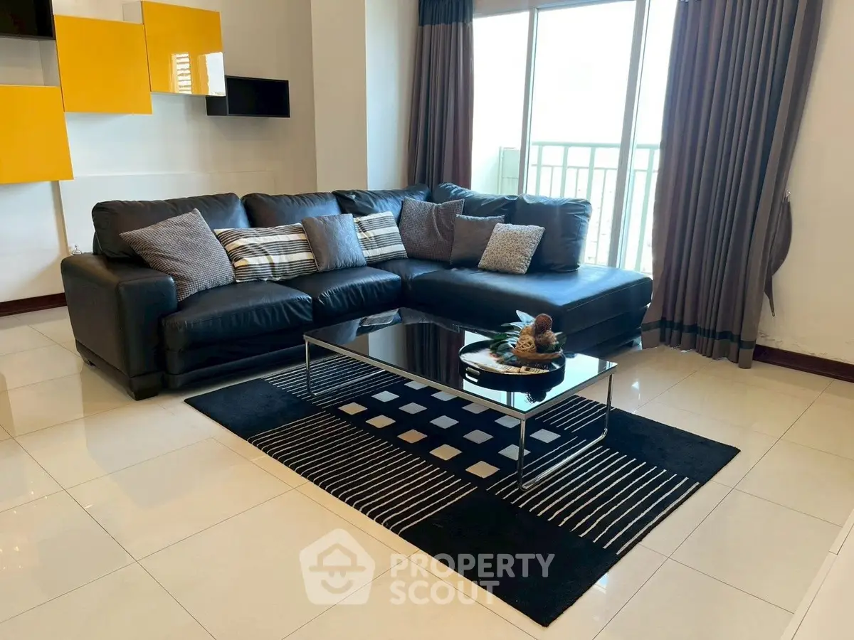 Modern living room with stylish black sofa and chic decor in a bright apartment.