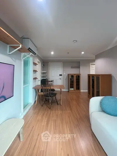 Spacious living room with modern furnishings and wooden flooring, perfect for comfortable living.
