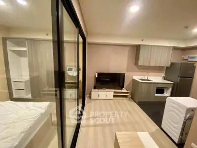 Modern studio apartment with open layout, featuring a compact kitchen and cozy living area.