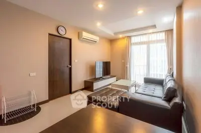 Spacious modern living room with leather sofa and large window for natural light.