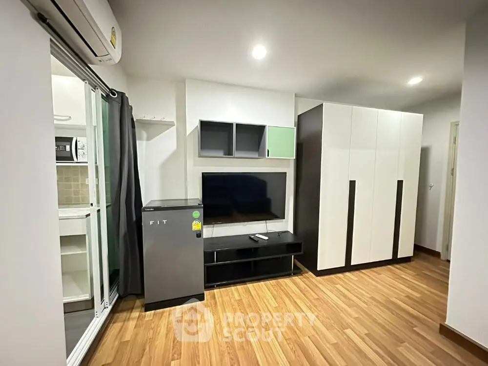 Modern living room with sleek furniture and wooden flooring in a stylish apartment.