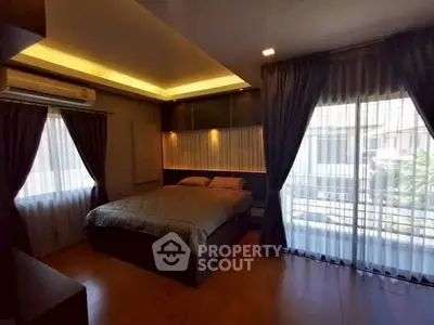 Luxurious bedroom with modern lighting and large windows offering natural light.