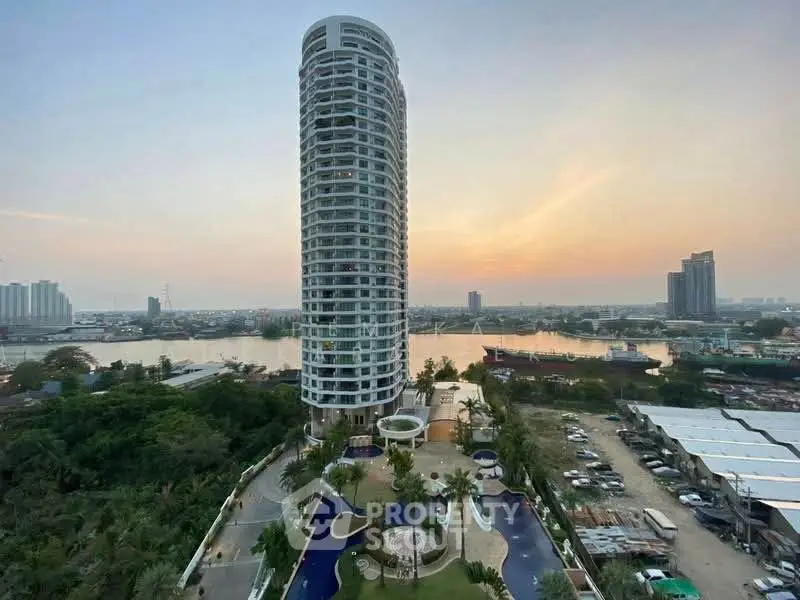 Stunning high-rise building with river view and luxurious pool area at sunset.