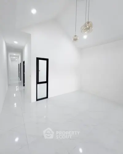 Spacious minimalist interior with high ceilings and modern lighting, perfect for customization.