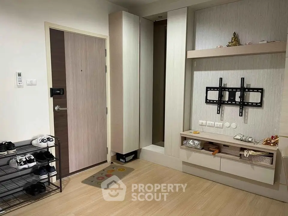 Modern apartment entrance with shoe rack and wall-mounted TV bracket