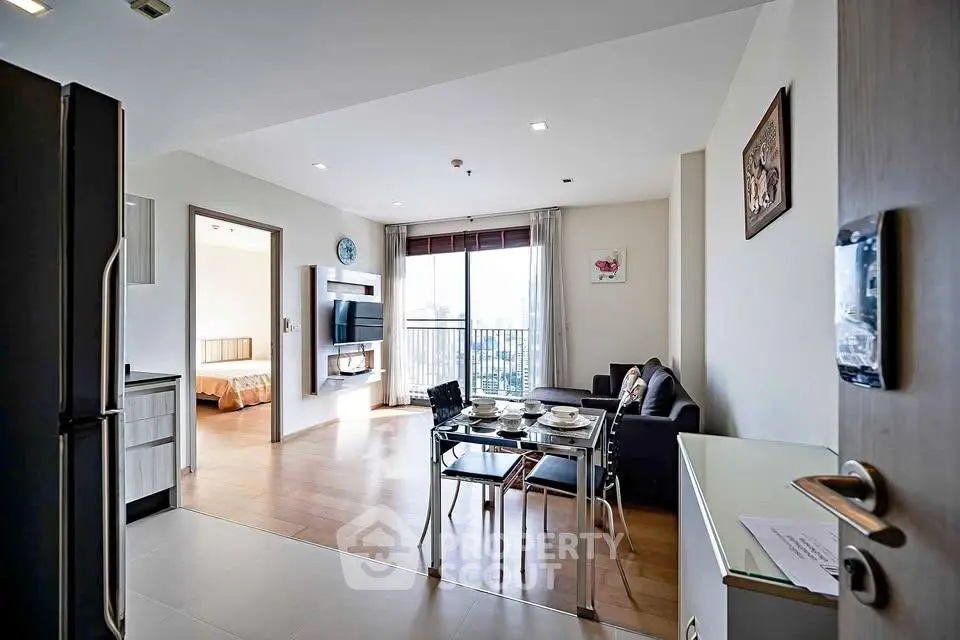 Spacious open-plan living room with dining area and balcony view in modern apartment.