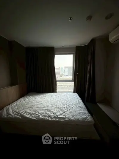 Cozy bedroom with city view, featuring a comfortable bed and air conditioning.