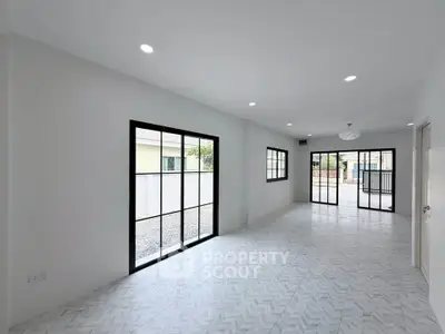 Spacious modern living room with large windows and sleek tile flooring