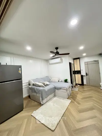 Modern living room with cozy sectional sofa and sleek refrigerator