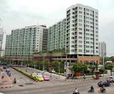 Modern high-rise apartment building with street view and urban surroundings.