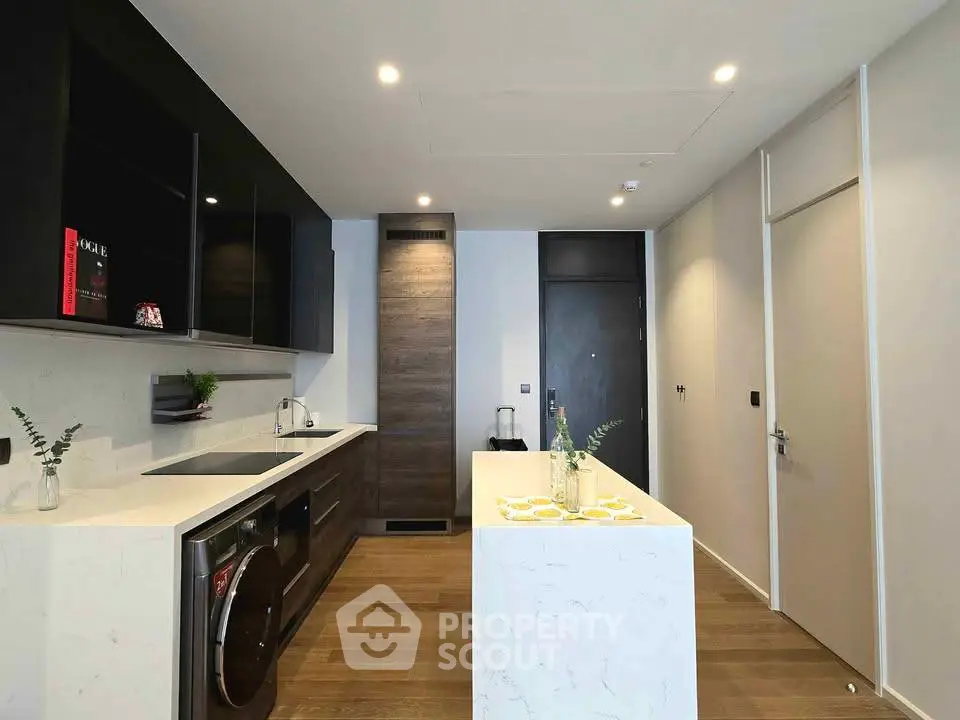 Modern kitchen with sleek design, featuring an island and integrated appliances in a stylish apartment.