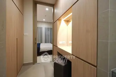 Modern bedroom entrance with built-in wooden storage and soft lighting