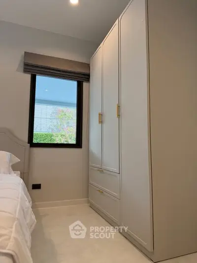 Modern bedroom with sleek wardrobe and window view