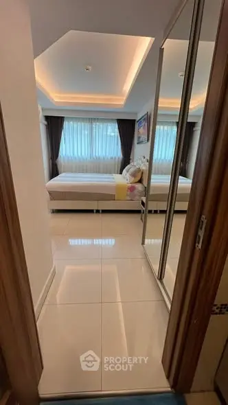 Modern bedroom with mirrored closet and ambient lighting