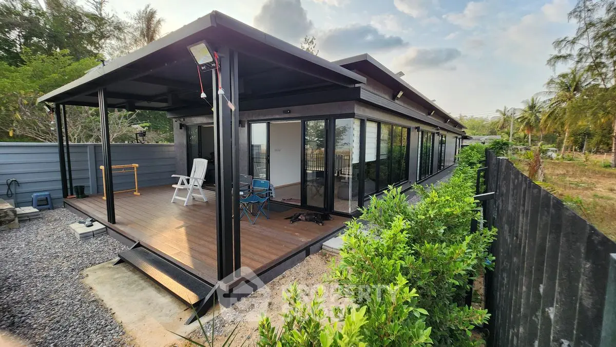 Modern container home with spacious deck and lush greenery