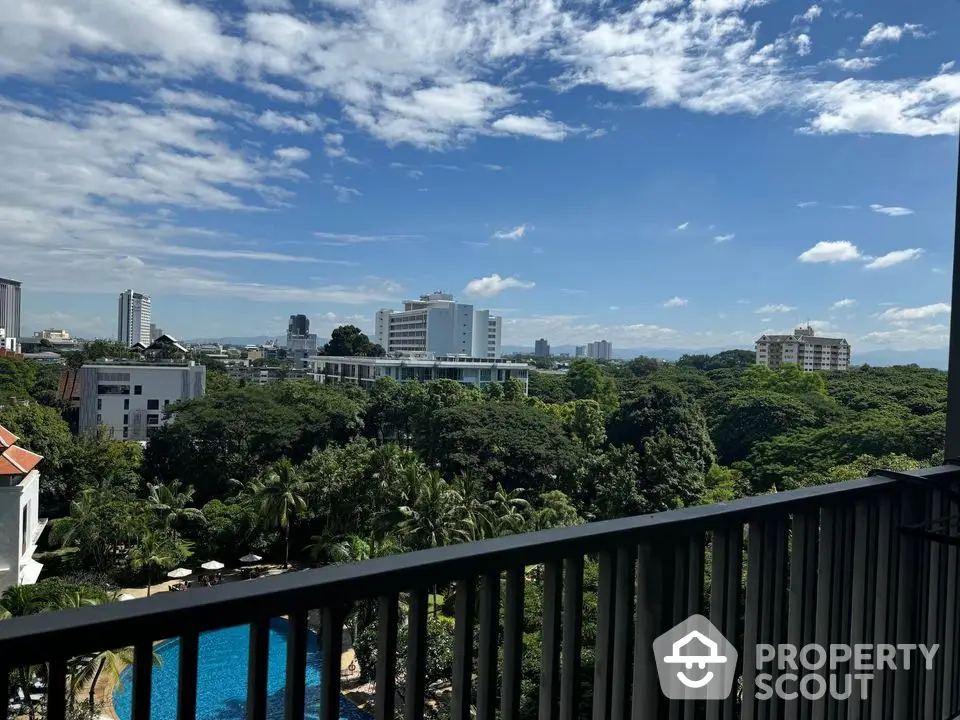 Stunning balcony view overlooking lush greenery and cityscape with a pool in the foreground.