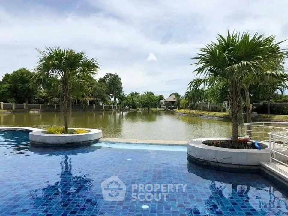 Luxurious poolside view with lush greenery and serene water body