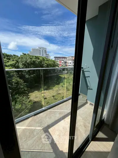 Stunning balcony view with lush greenery and cityscape, perfect for relaxation and enjoying nature.