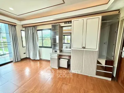 Spacious bedroom with built-in wardrobe and large windows offering natural light.