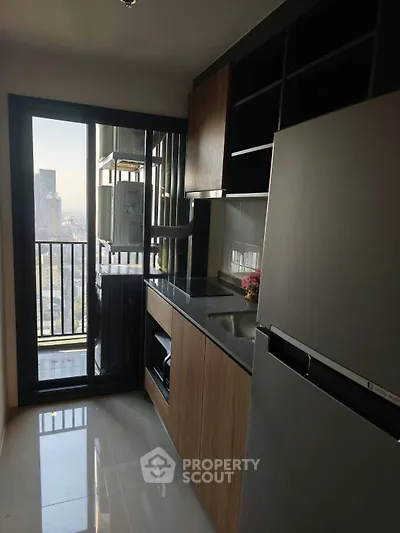 Modern kitchen with sleek appliances and city view from balcony