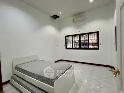 Spacious bedroom with minimalist design and ample natural light