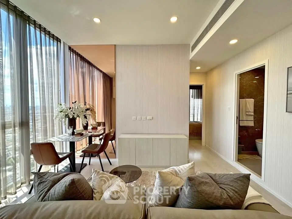 Luxurious modern living room with elegant dining area and floor-to-ceiling windows.