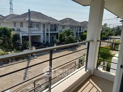 Spacious balcony with a view of modern suburban homes and lush greenery.