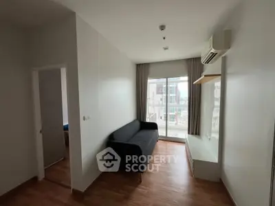 Modern living room with sleek design, featuring a black sofa and large window for natural light.