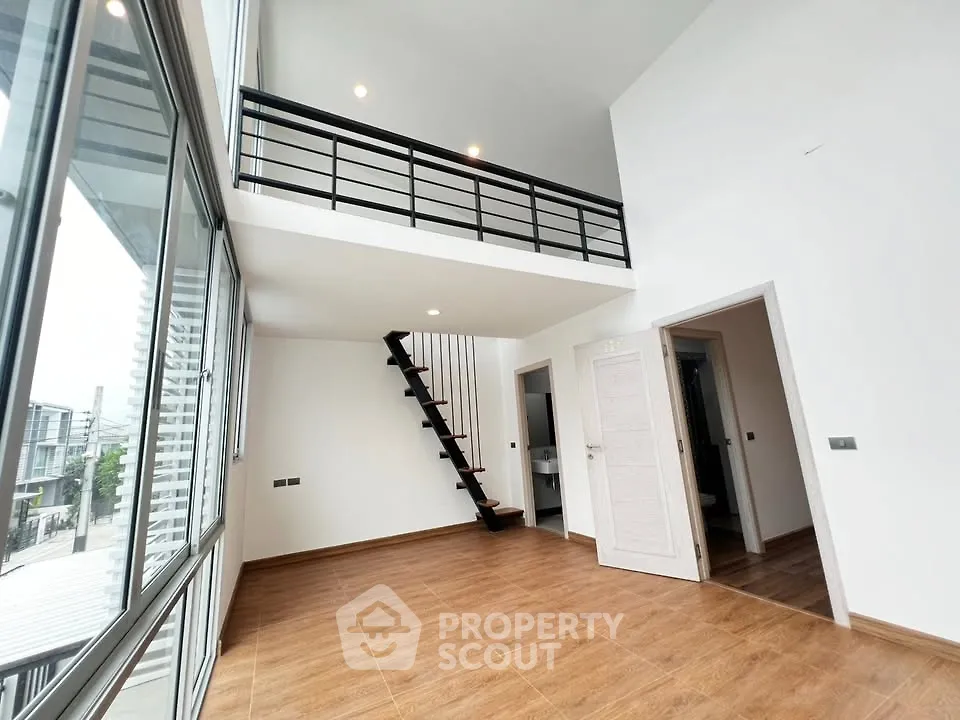Spacious modern loft with high ceilings and mezzanine in a bright, open living area.