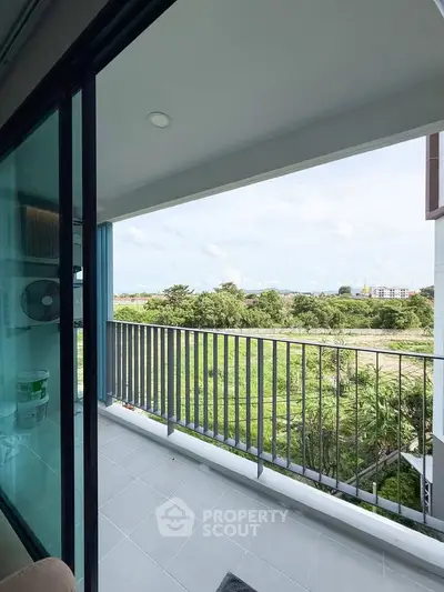 Spacious balcony with scenic view of greenery and open sky, perfect for relaxation.