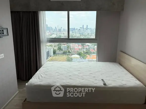Modern bedroom with city view and large window, featuring a minimalist design and natural light.